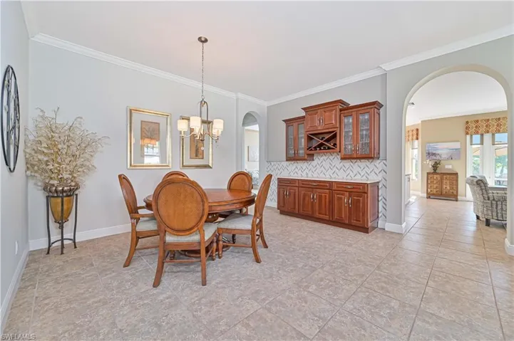 Dining area featuring crown molding, light tile patterned floors, and a chandelier