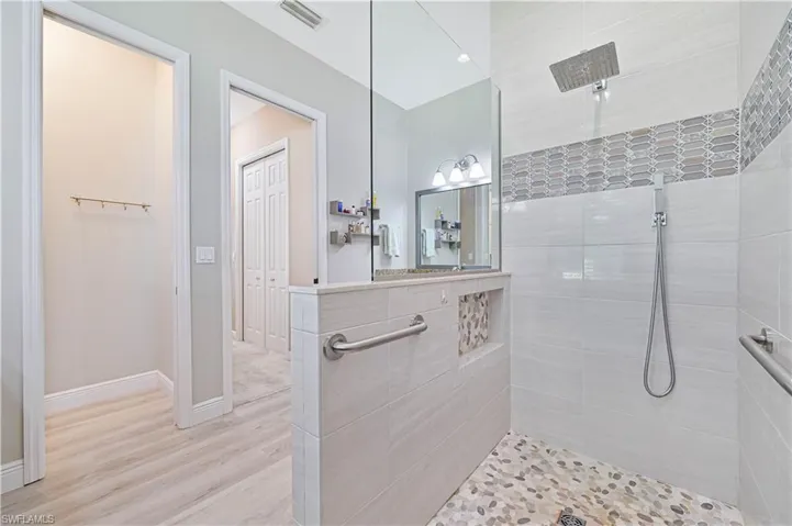 Bathroom featuring a tile shower and wood-type flooring