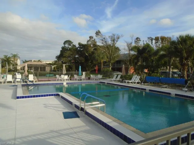 Community pool featuring fence and a patio