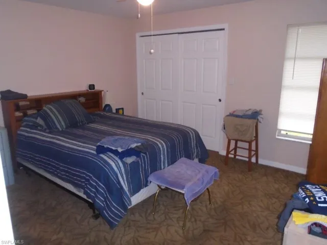Bedroom featuring a closet, carpet floors, and baseboards