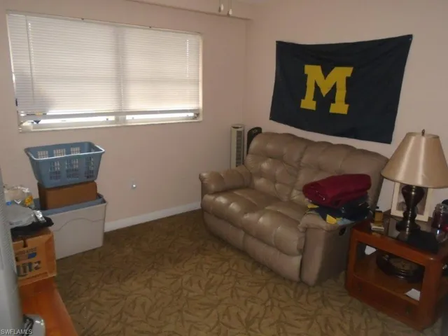 Carpeted living area featuring baseboards