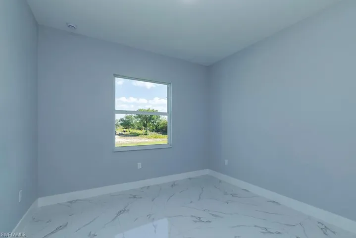 Unfurnished room with baseboards and marble finish floor