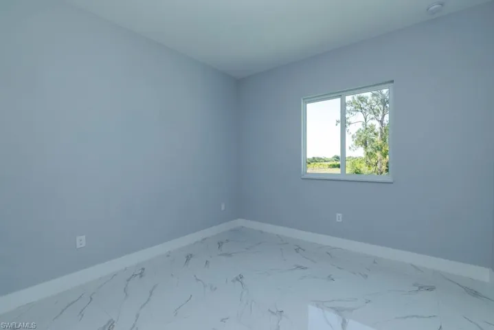 Empty room featuring baseboards and marble finish floor