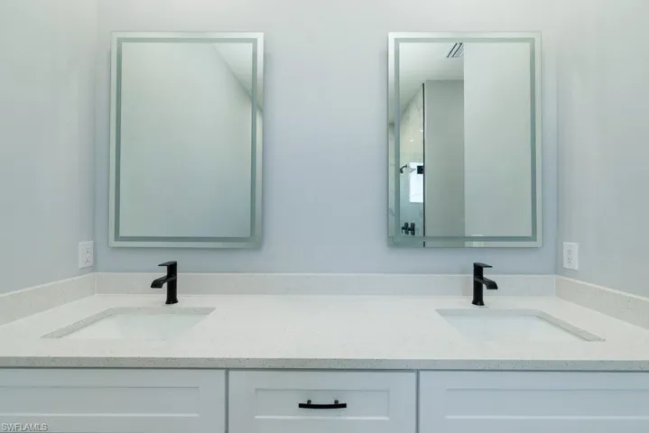 Full bath featuring double vanity and a sink