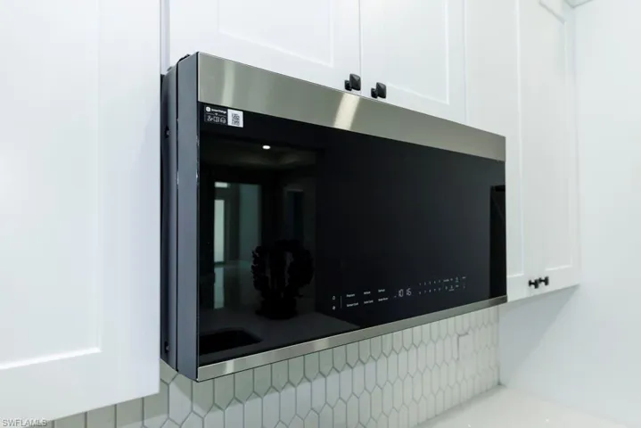 Details featuring white cabinetry and stainless steel microwave