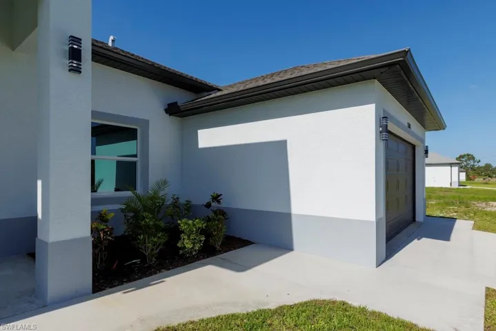 View of side of home featuring stucco siding and a garage