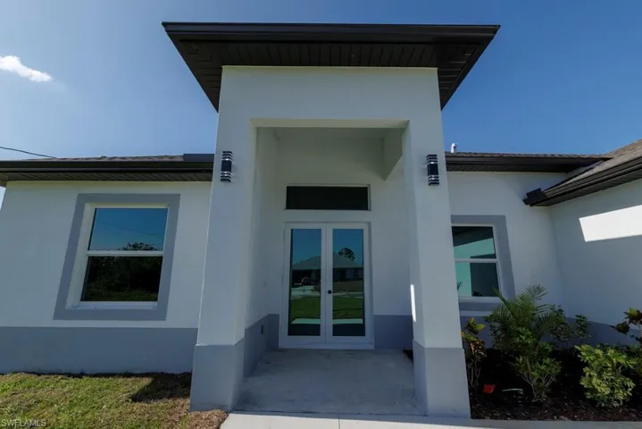 Doorway to property featuring stucco siding and french doors