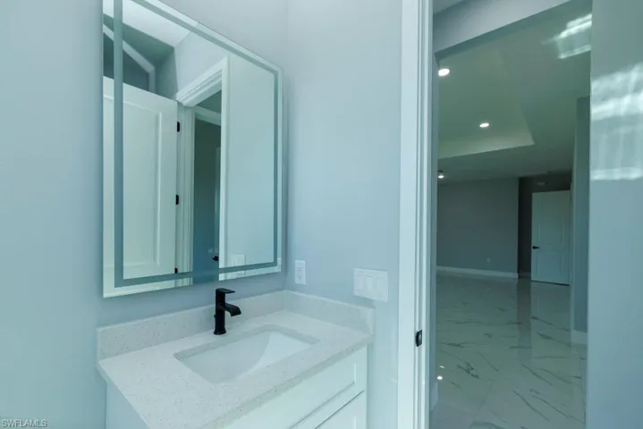 Bathroom featuring vanity, baseboards, recessed lighting, and marble finish floor