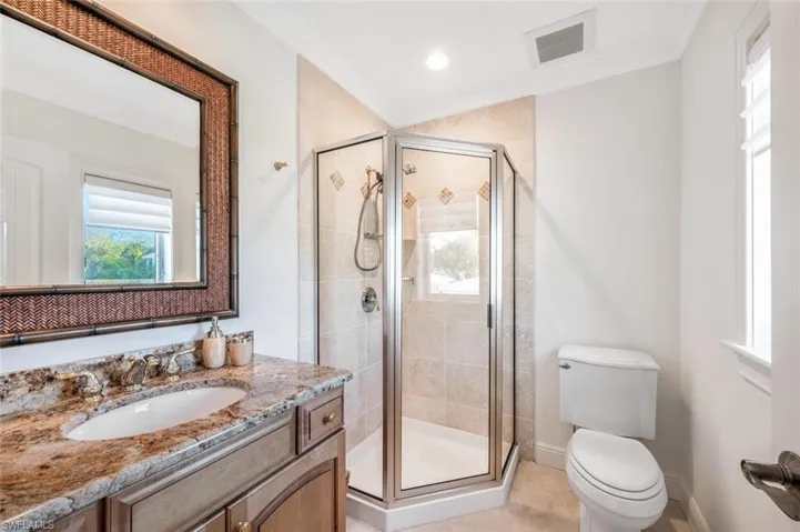 Bathroom with vanity, crown molding, toilet, and walk in shower
