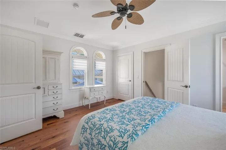 Bedroom featuring hardwood / wood-style flooring, ceiling fan, and crown molding