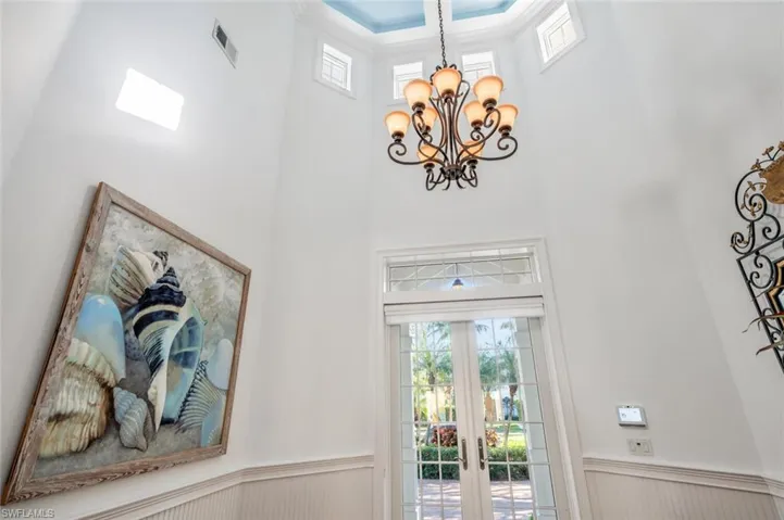 Entryway with a towering ceiling and a chandelier