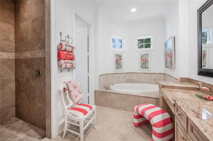Bathroom featuring vanity, crown molding, and separate shower and tub