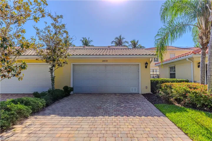 View of front of home with decorative driveway, stucco siding, and a tiled roof
