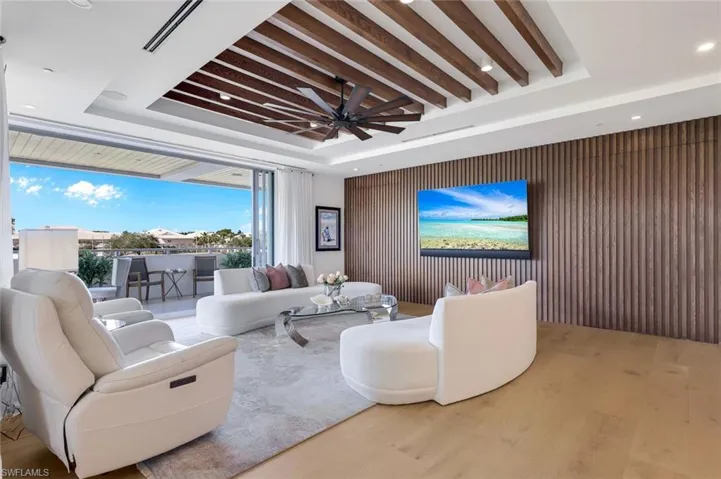 Glass doors pocket to open the entire living room to the cool breezes.  Pivot doors are closed for an impressive linear plank wood wall