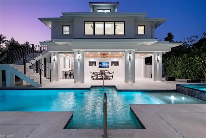 Rear view of house featuring a patio and a swimming pool with hot tub