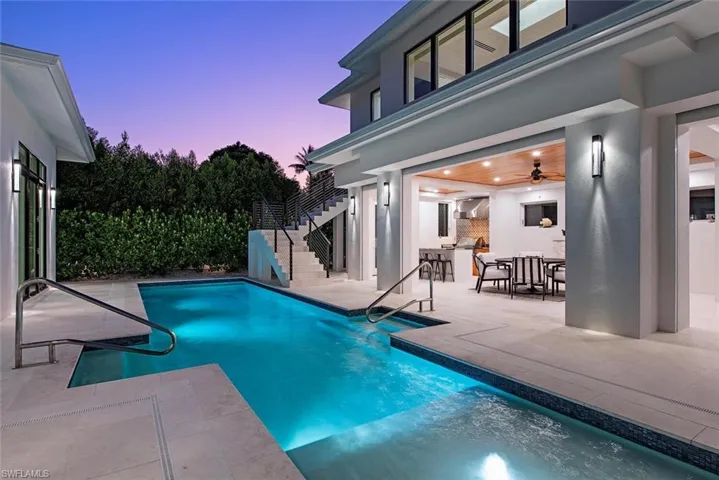 Pool at dusk featuring a patio area and ceiling fan