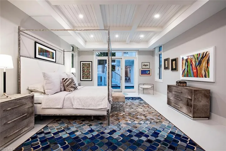 Bedroom with coffered ceiling, beam ceiling, and a barn door