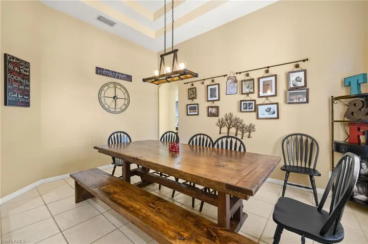 Dining room featuring light tile patterned flooring, a chandelier, and baseboards