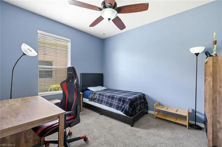 Bedroom with multiple windows, carpet floors, baseboards, and a desk