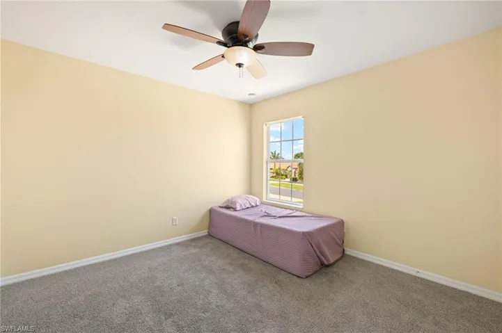 Bedroom featuring carpet, baseboards, and ceiling fan