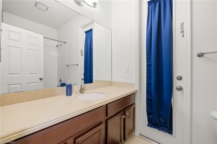 Full bathroom with vanity, toilet, and a shower