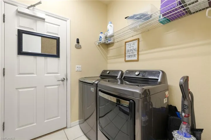 Washroom featuring washing machine and dryer and light tile patterned floors