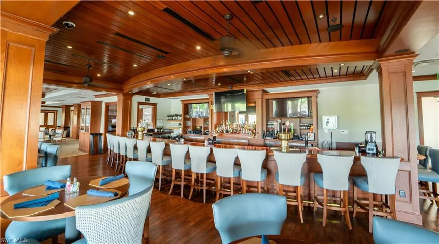 Community bar area featuring ornate columns, a wood ceiling with exposed beams, and recessed lighting