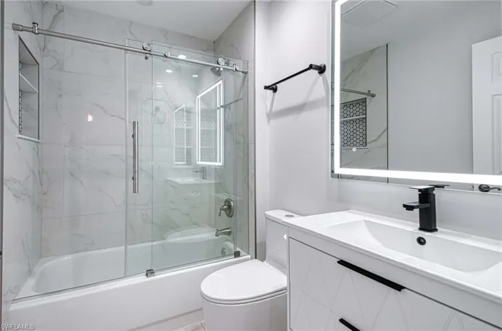 Full bathroom with vanity and enclosed tub / shower combo