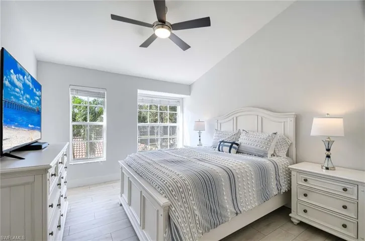 Bedroom with vaulted ceiling, ceiling fan, and light wood-type flooring