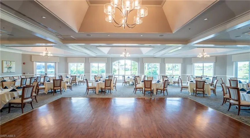 Dining space with a chandelier, ornamental molding, healthy amount of natural light, and wood finished floors