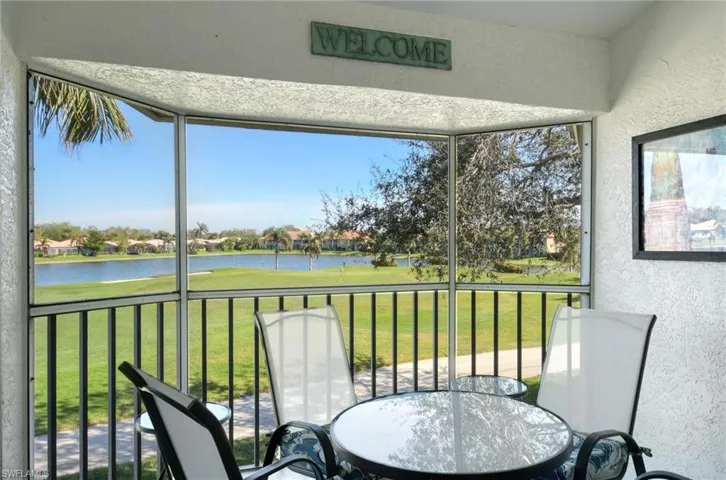 Sunroom with a water view, healthy amount of natural light, and view of golf course
