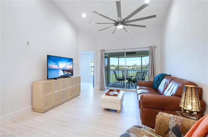 Living room featuring wood finished floors, high vaulted ceiling, ceiling fan, and recessed lighting