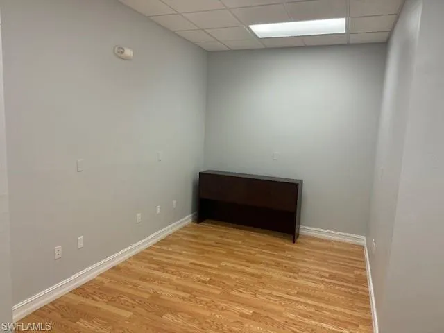 Spare room featuring light hardwood / wood-style floors and a drop ceiling
