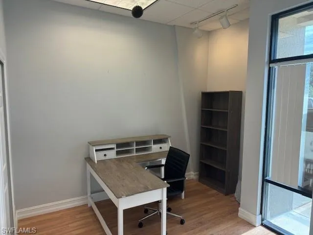 Home office featuring track lighting and light hardwood / wood-style floors