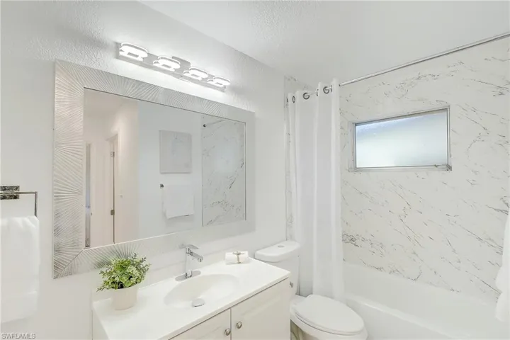 Bathroom with shower / tub combo, vanity, and toilet