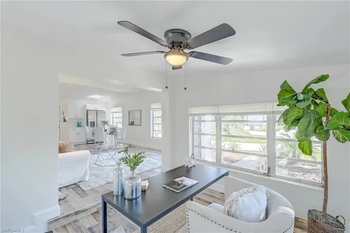 Living area featuring baseboards, a ceiling fan, and wood finished floors