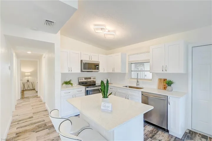 Kitchen featuring light countertops, white cabinetry, visible vents, and stainless steel appliances
