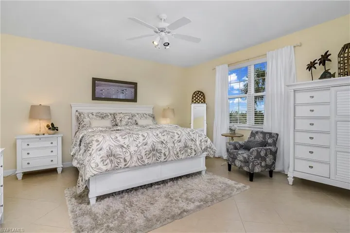Tiled bedroom featuring ceiling fan