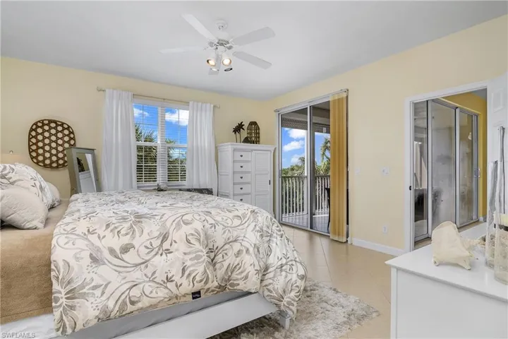Tiled bedroom with access to outside and ceiling fan