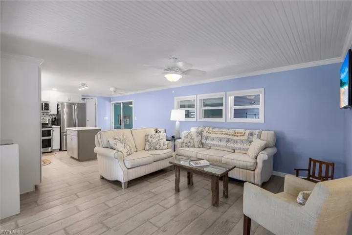 Living area featuring a beadboard ceiling, light blue walls, and laminate flooring
