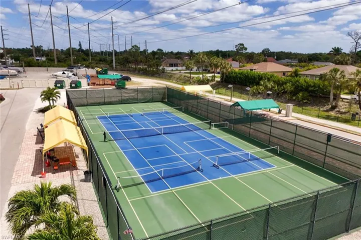 Recreational amenities include well-maintained tennis courts with blue and green playing surfaces and fencing
