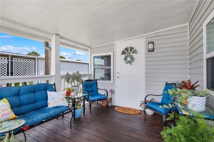 Inviting covered porch with wood flooring and light gray siding