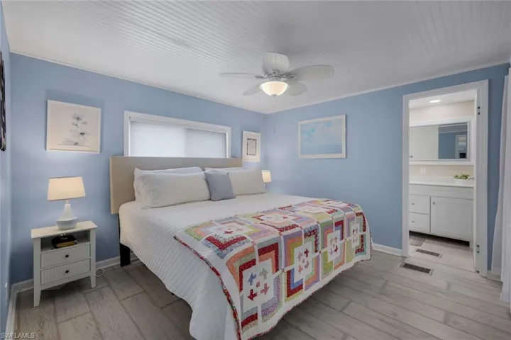 Bedroom featuring light blue walls, a white tongue and groove ceiling, and light-colored laminate flooring