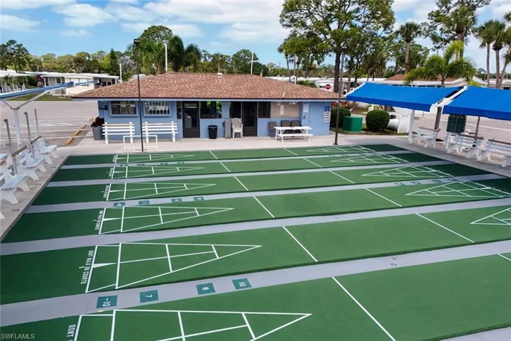Outdoor shuffleboard courts with seating and covered areas, providing a recreational space