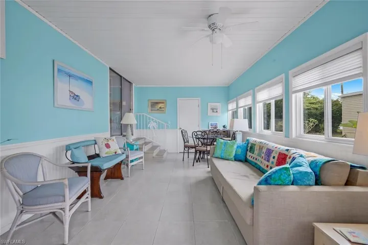 This room features light blue walls, white wainscoting, and a white beadboard ceiling with a ceiling fan