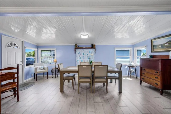 Dining area featuring light-toned flooring, a white beadboard ceiling, and light blue walls