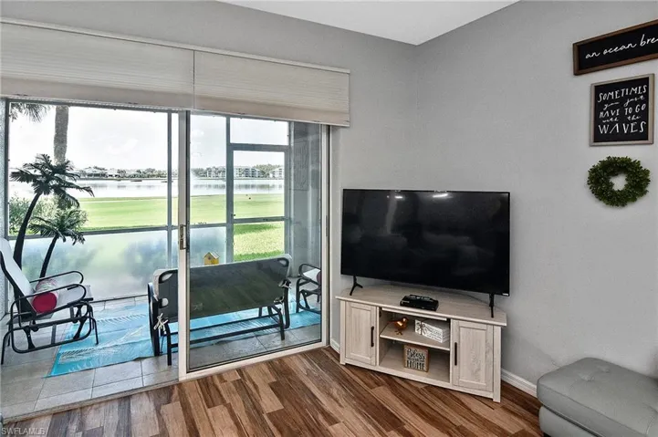 Sunroom / solarium featuring golf course view and a water view