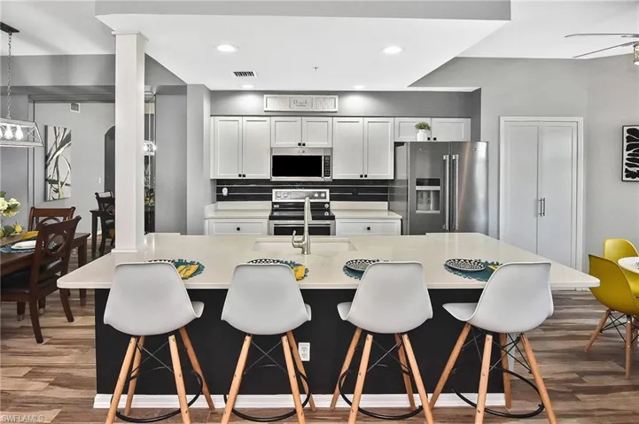 Dining area with wood finished floors, a ceiling fan, and recessed lighting