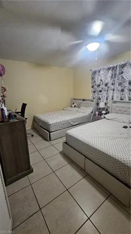 Bedroom featuring light tile patterned floors and ceiling fan