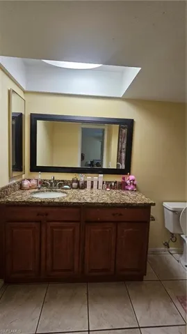 Bathroom with toilet, vanity, and tile patterned flooring